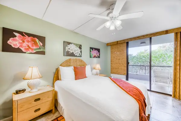 Beautifully styled bedroom interior featuring a cozy bed, vibrant throw blanket, matching nightstands, and elegant accent wall art! 🛏️✨