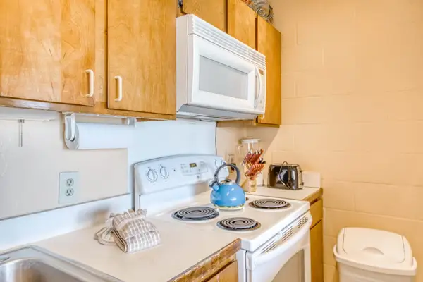 Detailed kitchen view featuring an electric stovetop range, built-in overhead microwave, and beautiful wood storage cabinets! 🍳🎛️☕