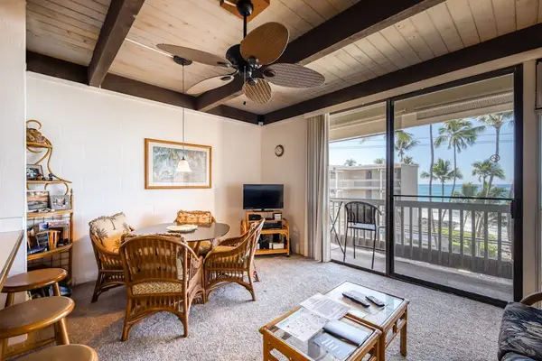 Spacious tropical lounge area featuring bamboo furniture, cooling ceiling fan, and a seamless sliding glass doorway to the balcony! 🛋️✨🌴😎