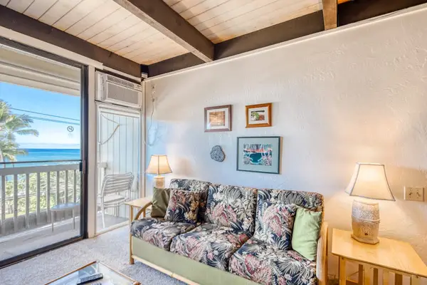 Cozy living area featuring high vaulted ceilings and beautiful ocean views from the balcony! 🛋️🌊✨