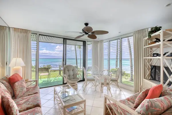 Bright living room features ocean windows, comfortable seating, and artwork