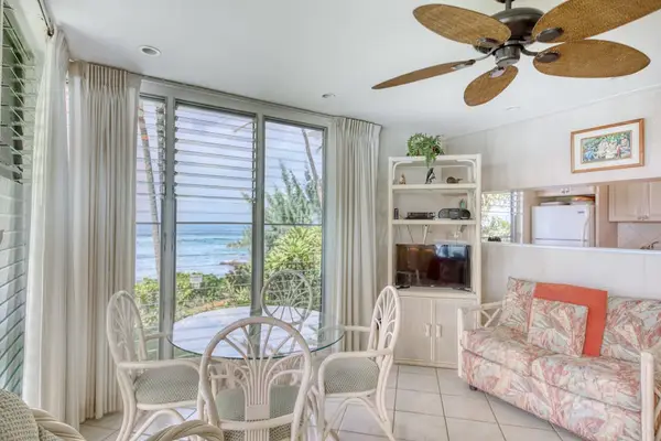 Dining area combines glass walls, comfortable chairs, and coastal views