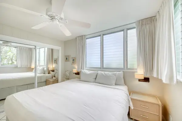 Cozy bedroom showcases soft linens, bedside tables, and bright windows