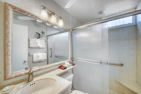 Contemporary bathroom features glass shower doors, tiled walls, and vanity