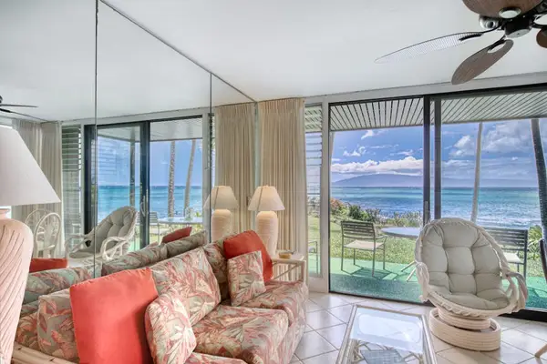 Ocean-facing lounge offers wicker chairs, glass walls, and colorful accents