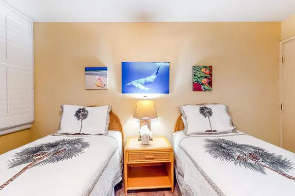 Twin bedroom with cheerful coastal artwork