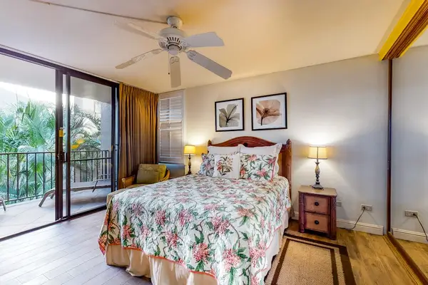 Bright bedroom with floral bedding and balcony access