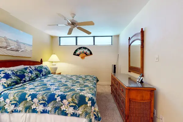 Spacious Primary Bedroom with Wooden Dresser & Natural Light