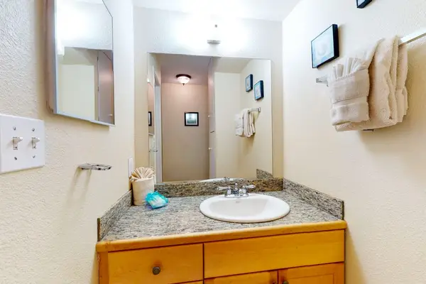 Bathroom Vanity Area with Granite Countertop & Bright Lighting