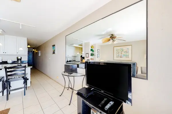 Light filled living room with fan to keep you cool and a flatscreen tv.