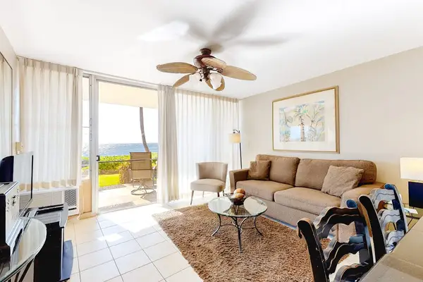 Light filled living room with fan to keep you cool and a flatscreen tv.