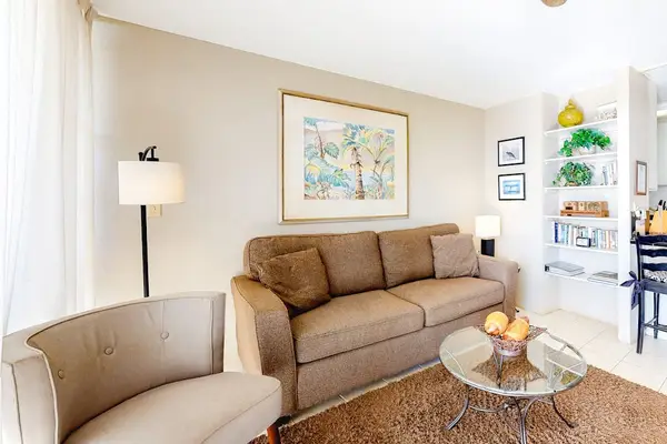 Light filled living room with fan to keep you cool and a flatscreen tv.