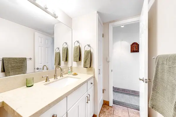 Bathroom with tiled walk in shower and updated finishes.