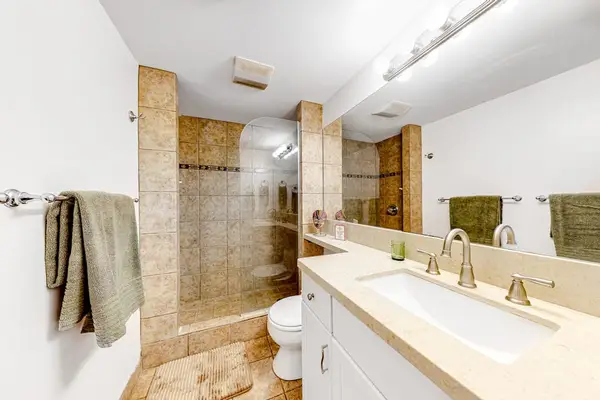 Bathroom with tiled walk in shower and updated finishes.