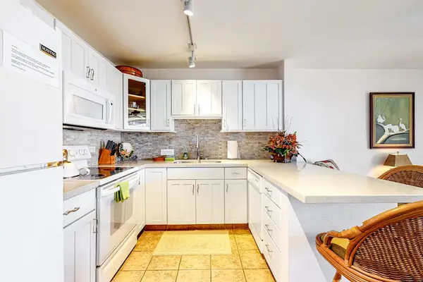 Updated open air kitchen with barstools for extra seating or for your sous chef.