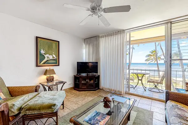 Bright living room with sliding glass doors, abundant natural light and flatscreen tv.