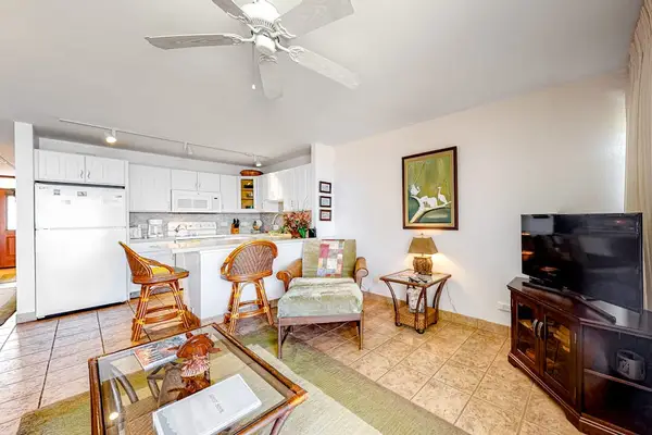 Bright living room with sliding glass doors, abundant natural light and flatscreen tv.