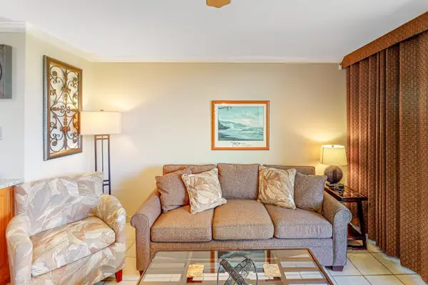 Living room with flat screen tv and lots of natural streaming in from the lanai.