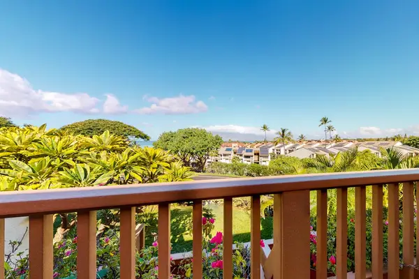 Balcony railing frames sweeping tropical hills and distant island scenery