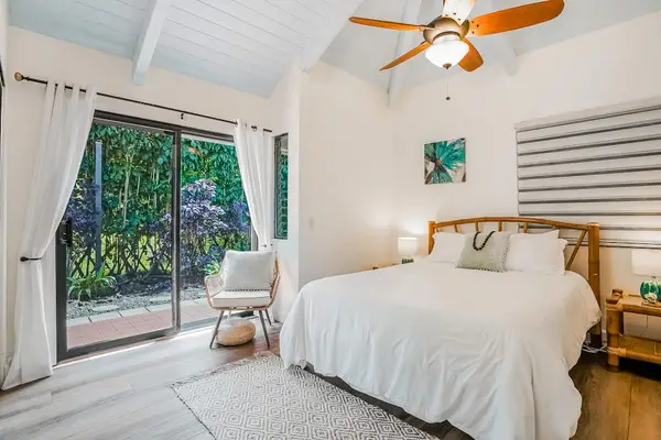 Guest bedroom with queen bed and lanai access.