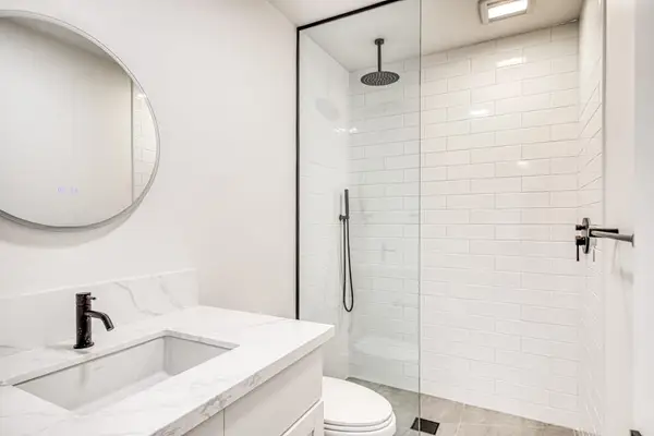 Pristine Modern Bathroom Featuring A Custom Subway Tile Shower