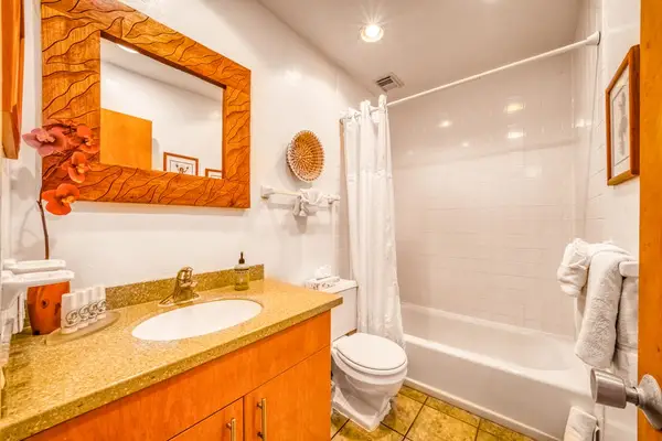 Spacious full bathroom featuring a single sink vanity, toilet, and clean shower/tub combo