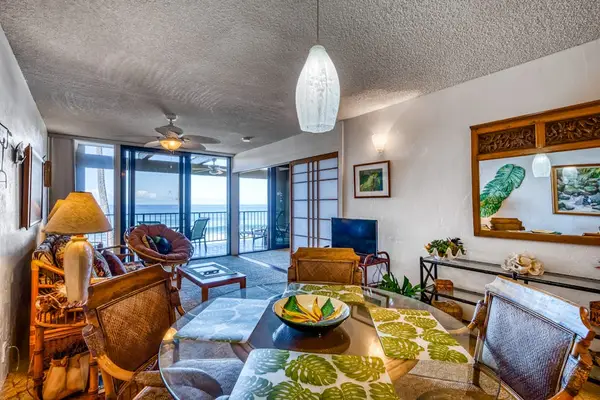 Spacious open floor plan showing the dining table, living room, and views out to the balcony