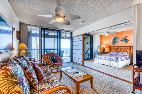 Bright open-concept living area and adjacent bedroom suite with large sliding doors to a private balcony