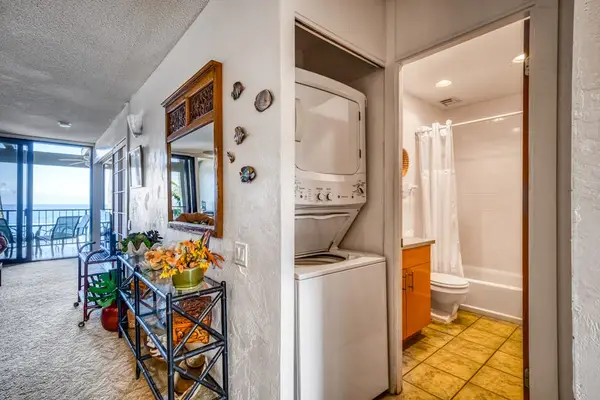 Convenient in-unit stacked washer and dryer located just outside the full guest bathroom