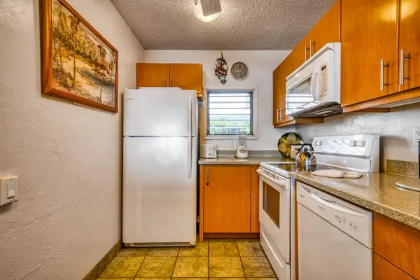 Spacious kitchen layout featuring a refrigerator, stove, microwave, double sink, and ample cabinet storage