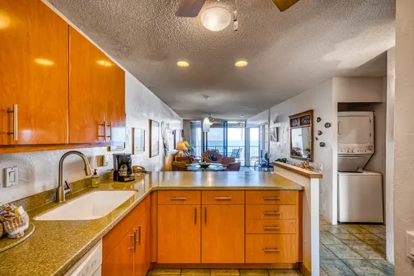 Functional kitchen counter and sink overlooking the spacious, open-concept living area