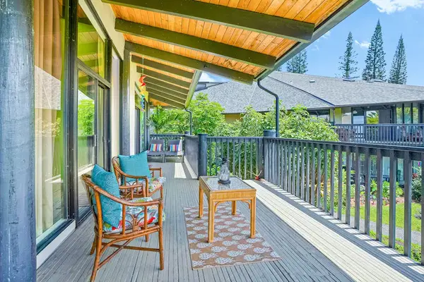 Covered lanai with outdoor seating overlooking the greenery