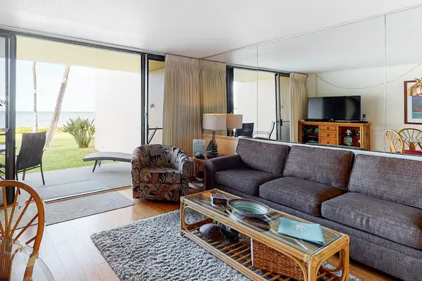 Living room with sleeper sofa and a flat screen tv.  Lots of natural light streaming in from the lanai.
