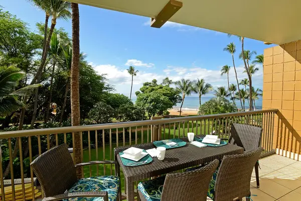Ocean-view balcony with outdoor dining and tropical scenery