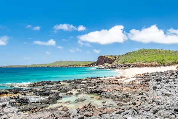 Rocky coastline frames turquoise water and distant green island views