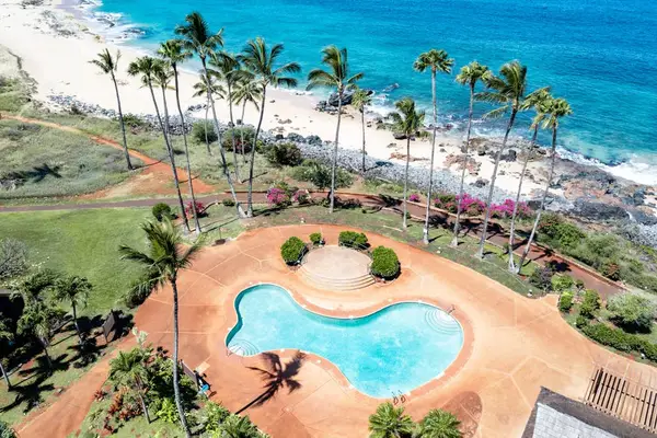 Aerial coastline reveals resort grounds beach and Pacific Ocean views