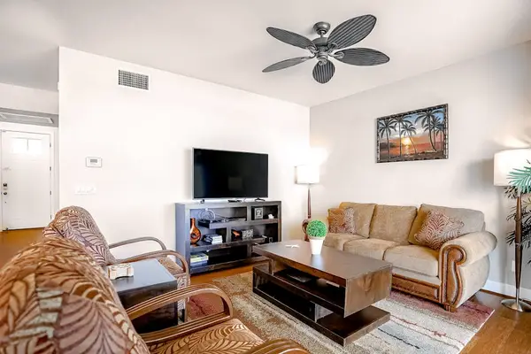 Spacious living room with comfortable seating, flat screen tv and natural light streaming in from the private lanai.