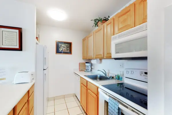 The fully equipped kitchen boasts modern appliances, including a fridge, stove, oven, and dishwasher, making meal preparation a breeze.