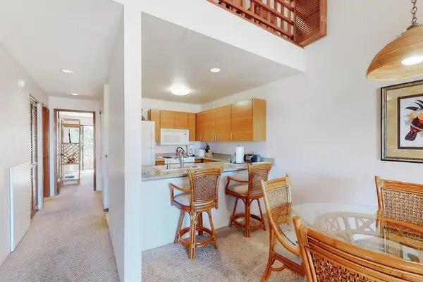 Dining area with rattan chairs and kitchen views