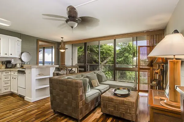 Lovely living room with a flat screen tv and light coming in from the lanai and views of the Pacific Ocean.