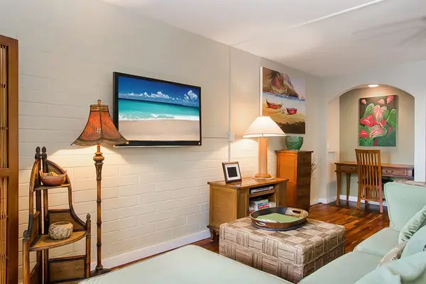 Lovely living room with a flat screen tv and light coming in from the lanai and views of the Pacific Ocean.