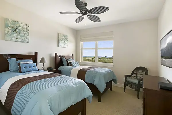 Guest room with two twin beds and a flat screen tv.