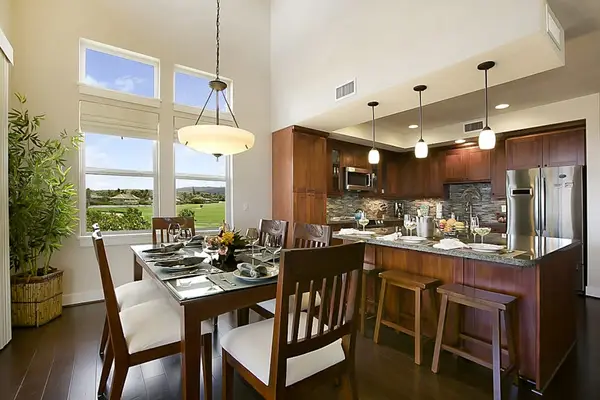 Lovely dining room with seating for six at the table and three additional seats at island in the kitchen.