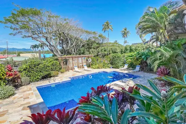 Resort-style pool surrounded by lush tropical gardens