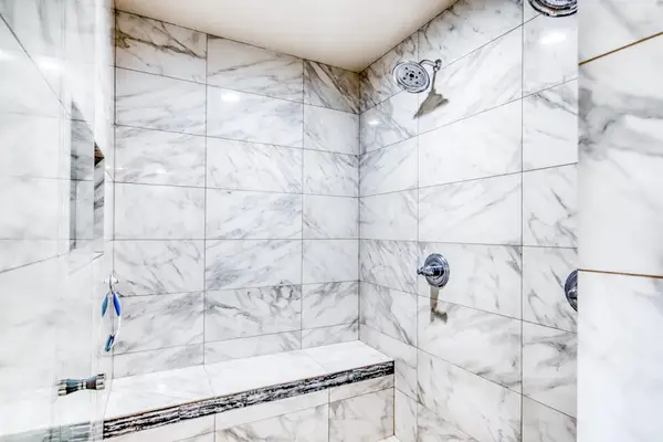 Spacious walk-in shower with elegant stone finishes