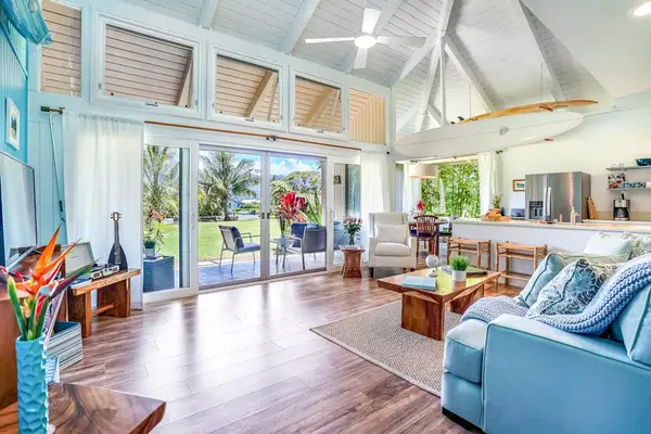 Open-concept living room with vaulted ceilings and lanai access.