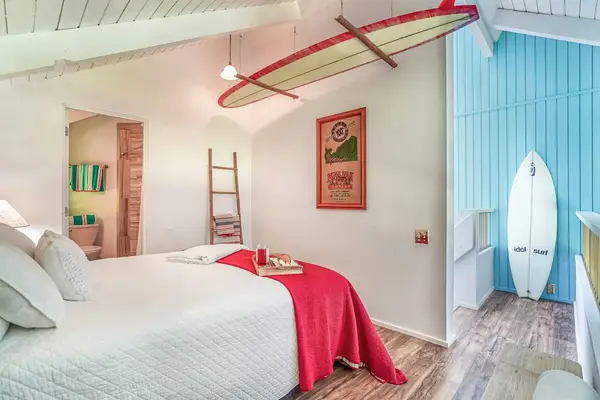 Cozy guest bedroom with tropical décor and vaulted ceilings.