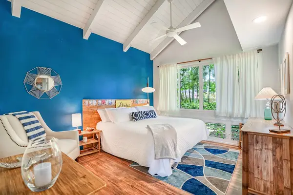 Relax in the spacious primary bedroom with tropical décor.