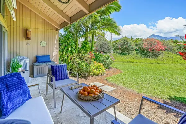 Private lanai with comfortable seating surrounded by lush greenery.