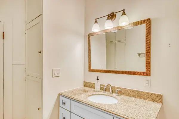 Main bathroom vanity provides storage and a well-lit mirror